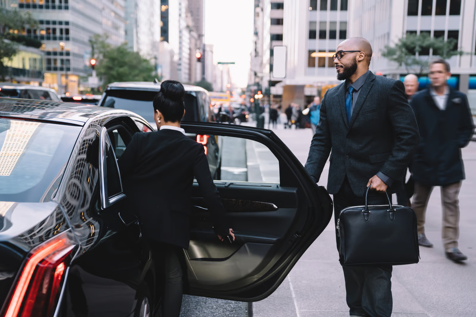 Chauffeur öffnet die Tür für einen Geschäftsreisenden