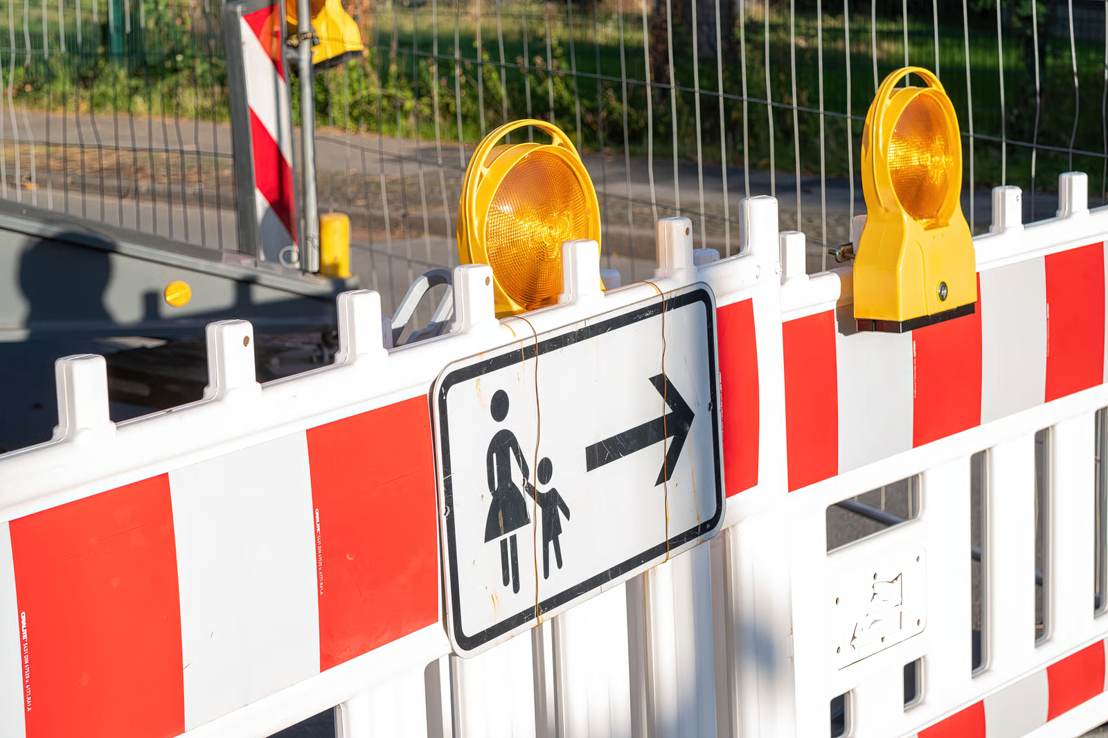 Baustellenabsperrung mit Warnleuchten und Fußgänger-Umleitung — temporäre Objektsicherung